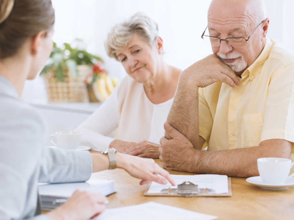 un couple de senior qui compare un contrat de mutuelle avec une conseillère