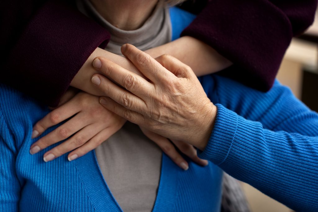 Une personne accompagnant un proche âgé à domicile, illustrant la charge des aidantes familiales.